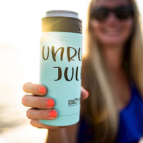 A person is holding a light blue can cooler with 